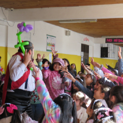 Tronky rodeado de niños en un colegio entregando globos