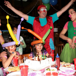 Tronky cantando cumpleaños feliz con la festejada y su familia