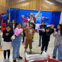 Tronky saludando a la cámara junto a un grupo de niños felices